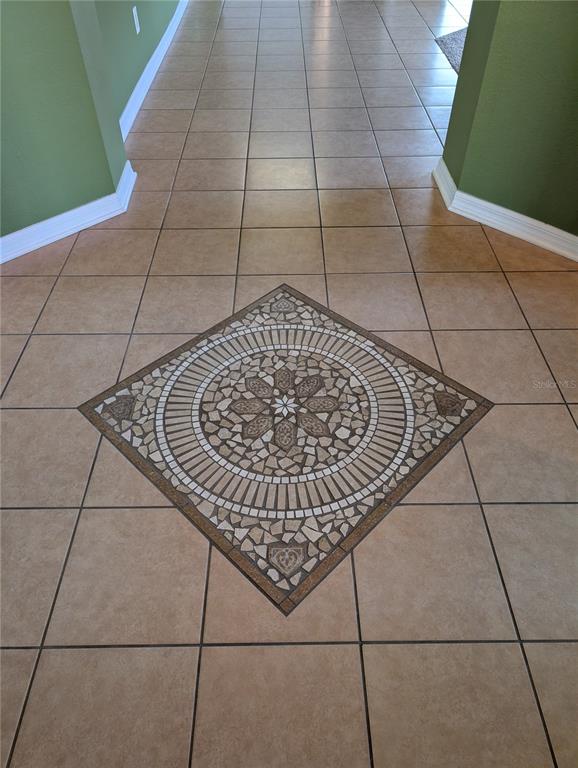 A tiled entryway floor features a decorative mosaic medallion centered within square ceramic tiles — 7343 FOREST MERE DRIVE, RIVERVIEW, FL