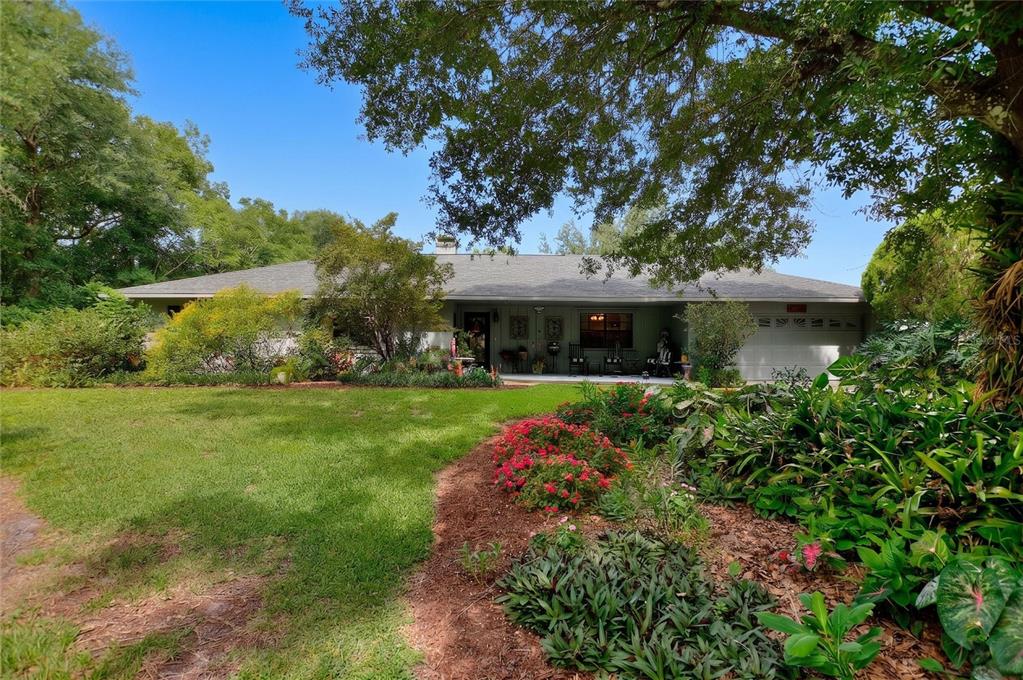 A single-story house with a gray roof, white garage, and a landscaped front yard — 7 LAKE ARROWHEAD DRIVE, WINTER HAVEN, FL