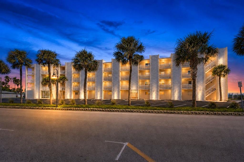 An elevator lobby with tile flooring, a directional sign for condo units, and an exterior view — 200 1ST AVENUE UNIT 207, ST PETE BEACH, FL