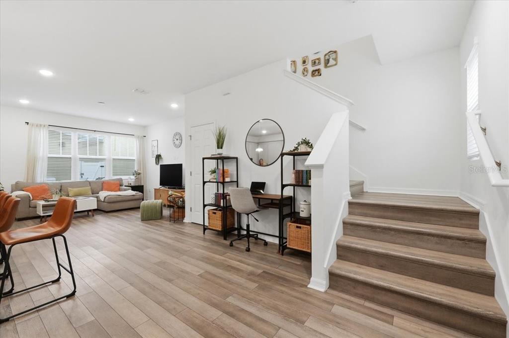 A living room features wood-look flooring, a staircase, and a built-in desk area — 2253 CELEBRATION BOULEVARD, CELEBRATION, FL