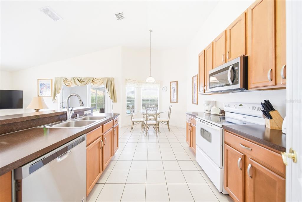 A living room features gray sofas, a wooden side table, and sliding doors to a pool — 723 OLD BRIDGE CIRCLE, DAVENPORT, FL
