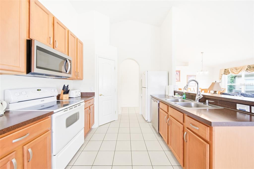 A dining area with a wooden table and chairs sits adjacent to a living room — 723 OLD BRIDGE CIRCLE, DAVENPORT, FL