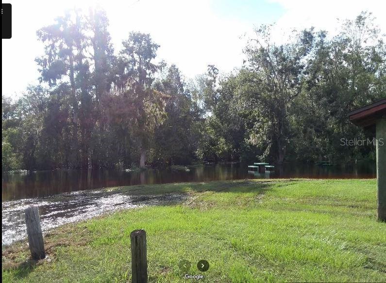 A grassy yard leads to a flooded area with a picnic table partially submerged in water — N/A, FORT MEADE, FL