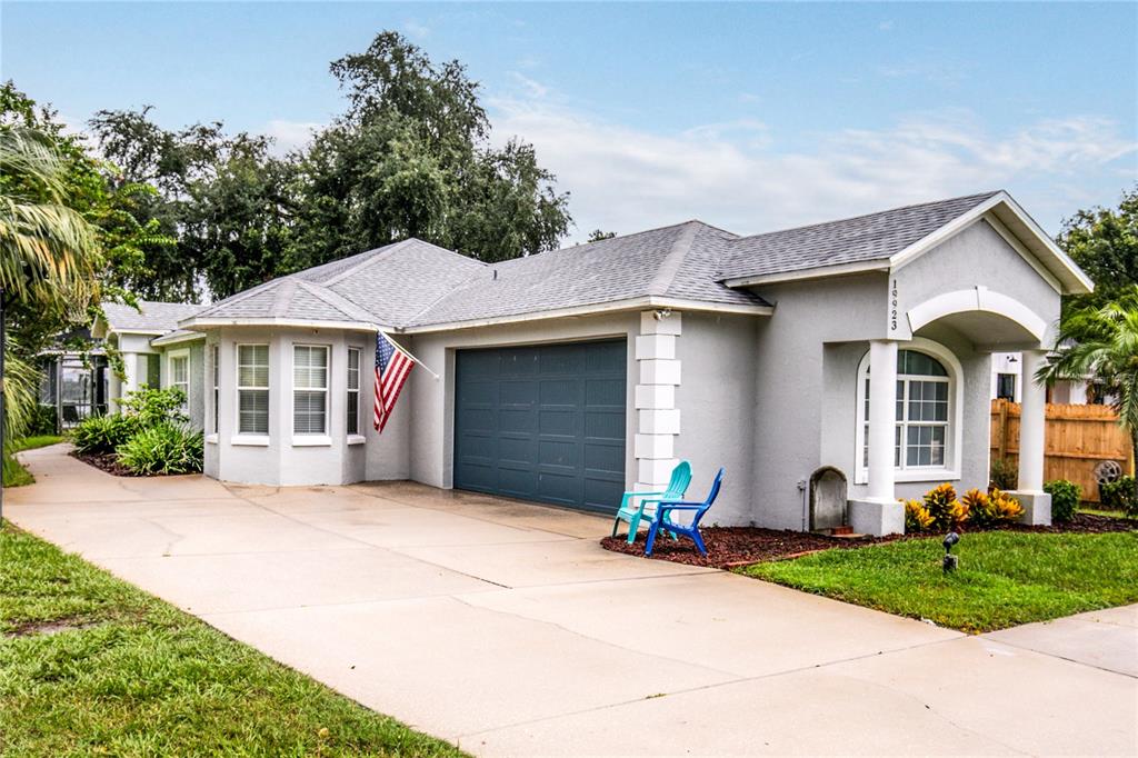 A single-story house with a gray exterior, a two-car garage, and a concrete driveway — 19923 W ELDORADO DRIVE, EUSTIS, FL