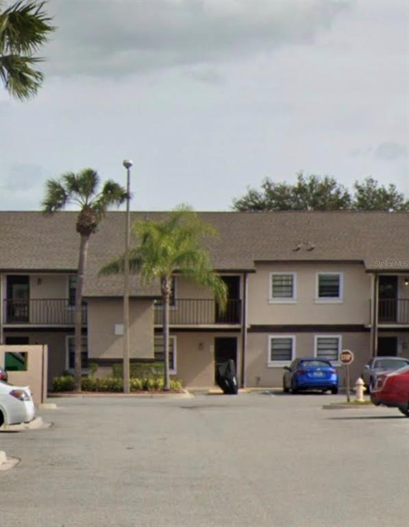 A two-story apartment building with a parking lot, palm trees, and several parked cars — 2921 REGENCY DRIVE UNIT 192921, MELBOURNE, FL