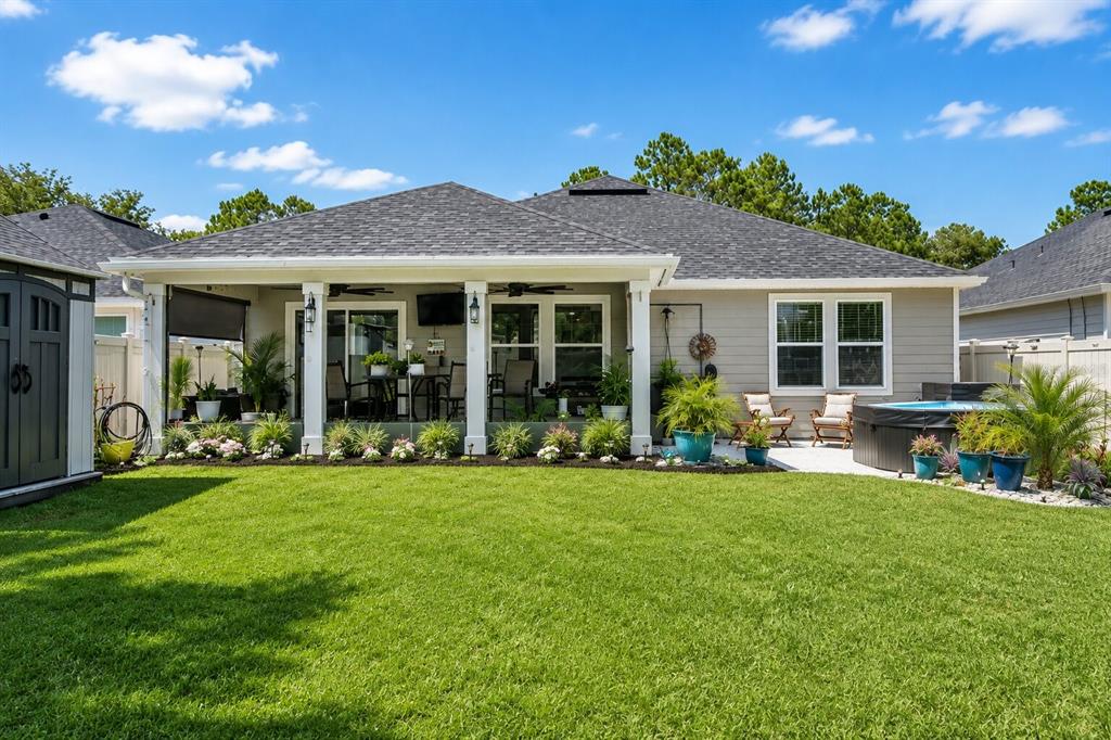 An open-concept living room and kitchen featuring leather recliners, wood-look flooring, and a center island — 7 SIGNET COURT, FLAGLER BEACH, FL