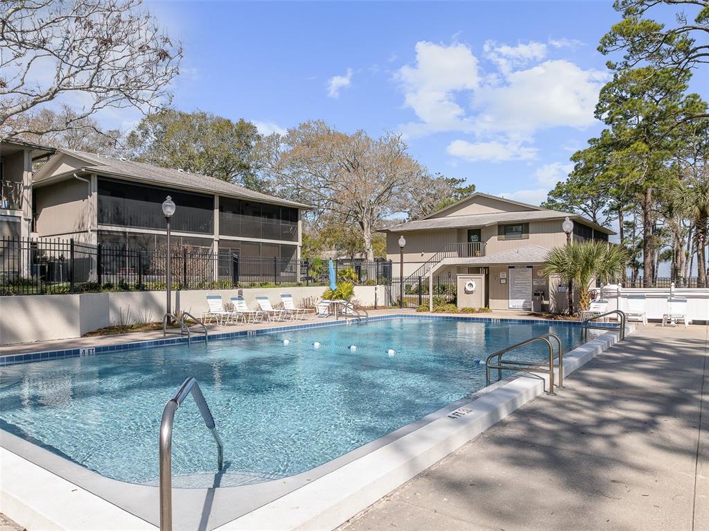 An outdoor swimming pool is surrounded by a concrete deck and two-story apartment buildings — 35 NAVARRA COURT UNIT 35, ST AUGUSTINE, FL