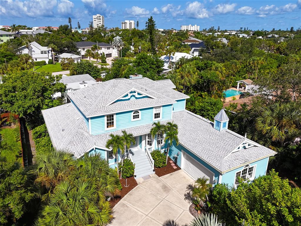 An aerial view of a light blue two-story house with a grey shingled roof — 5334 CALLE FLORIDA, SARASOTA, FL