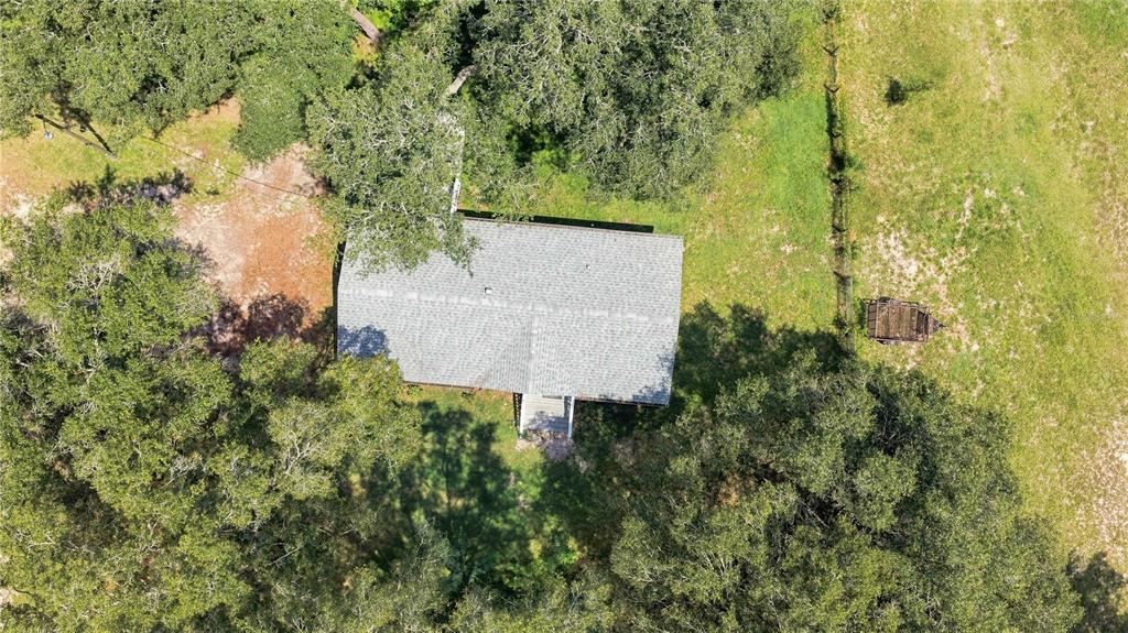 An aerial view shows a house with a gray roof surrounded by trees and grass — 2545 SE 178TH STREET, SUMMERFIELD, FL