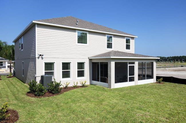 The rear exterior of a two-story house features light siding and a screened-in patio — 3418 MONARCH WAY, GREEN COVE SPRINGS, FL