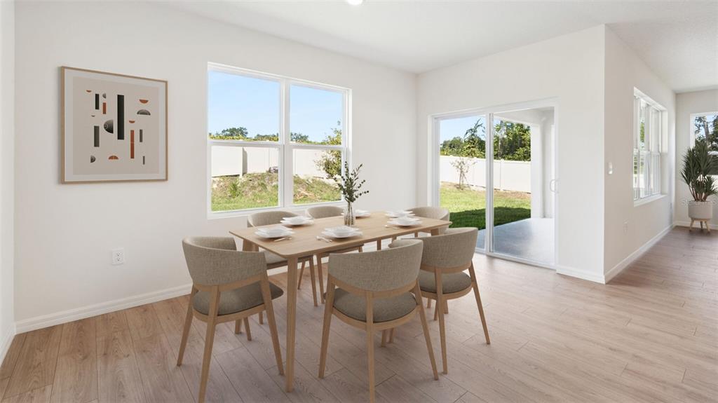 This dining room features light wood floors, a wooden table with chairs, and sliding doors — 24226 NW 13TH BOULEVARD, NEWBERRY, FL
