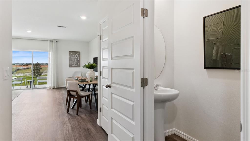 A view from a hallway into a dining area and a small powder room — 4294 BUTTERSCOTCH CIRCLE, LAKELAND, FL