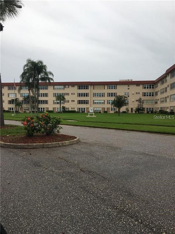 A gym room features stationary bikes, a weight rack with dumbbells, and large wall mirrors — 9950 62ND TERRACE N UNIT 112, ST PETERSBURG, FL