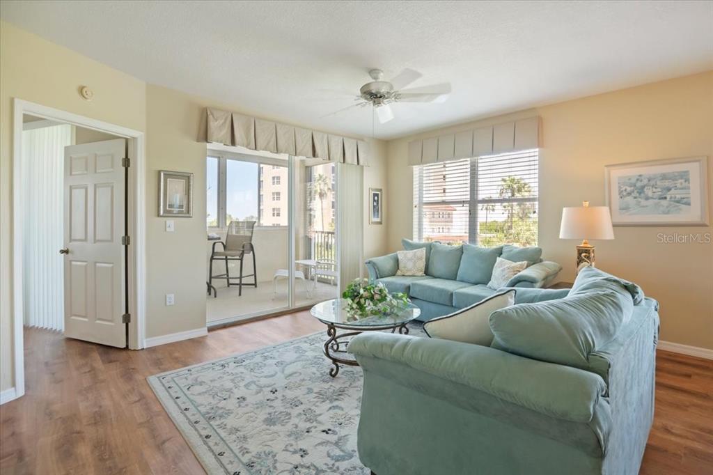 A living room features light blue sofas, a glass coffee table, and a sliding glass door — 2625 TERRA CEIA BAY BOULEVARD UNIT 206, PALMETTO, FL