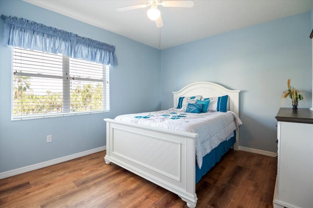 A bedroom features light blue walls, a white bed frame, and wood-look flooring — 2625 TERRA CEIA BAY BOULEVARD UNIT 206, PALMETTO, FL