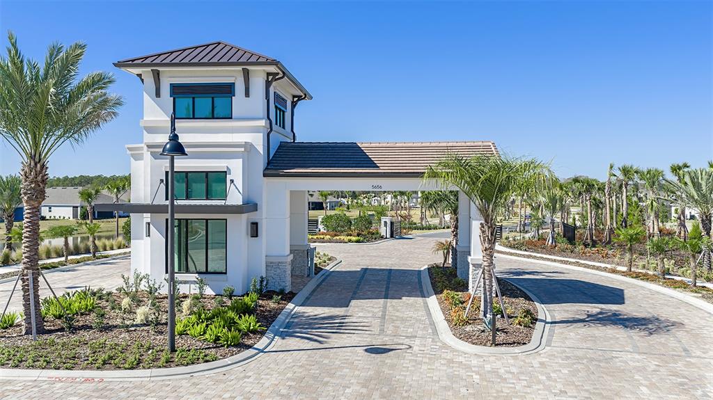 An outdoor swimming pool with lounge chairs and palm trees sits before a large building — 4451 OCHOS RIOS PLACE, KISSIMMEE, FL