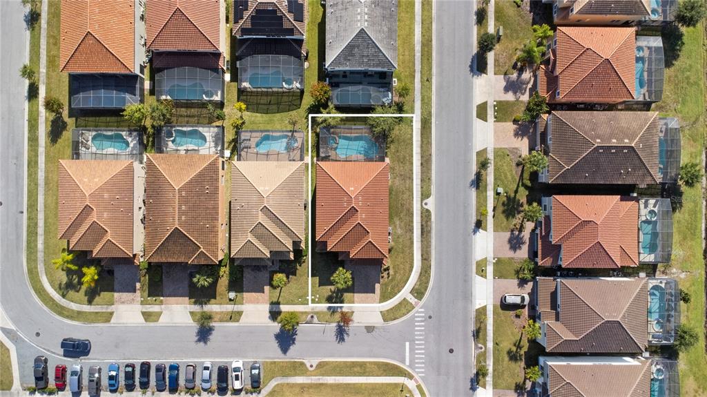 An aerial view shows a suburban house with a pool and screened enclosure on a corner — 4414 SHIVA LOOP, KISSIMMEE, FL