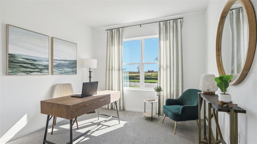 A home office features a wooden desk, a green armchair, and a large round mirror — 1213 12TH STREET SE, RUSKIN, FL