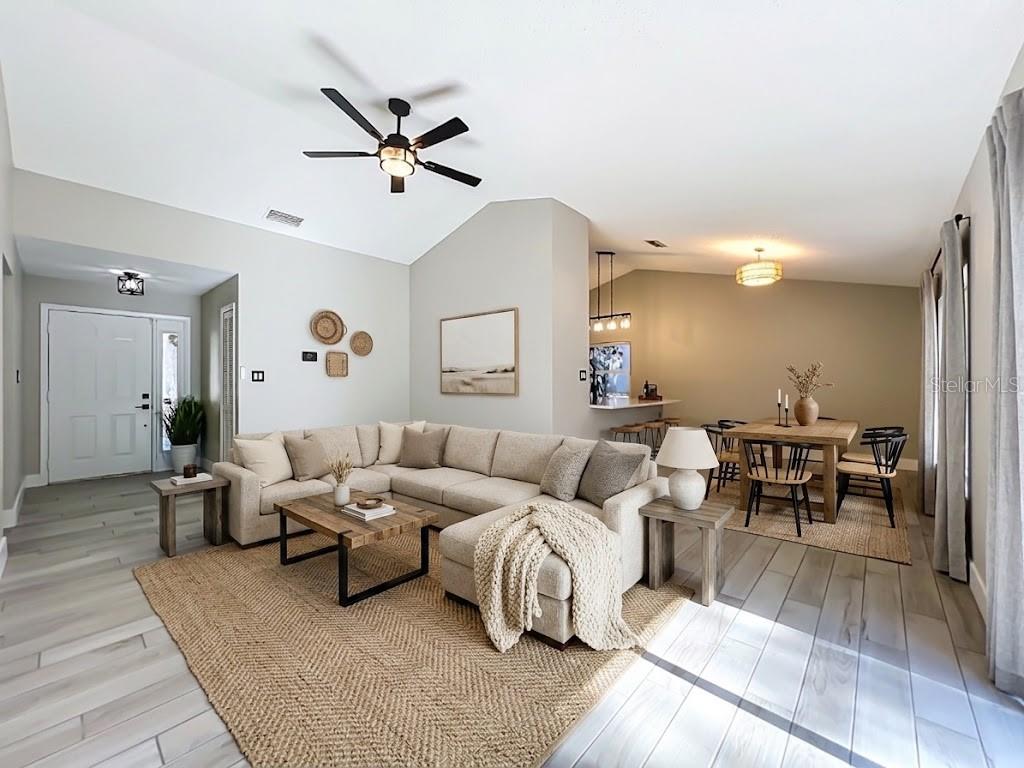 A living room and dining area feature a sectional sofa, wood furniture, and light flooring — 5915 GROVELINE DRIVE, ORLANDO, FL