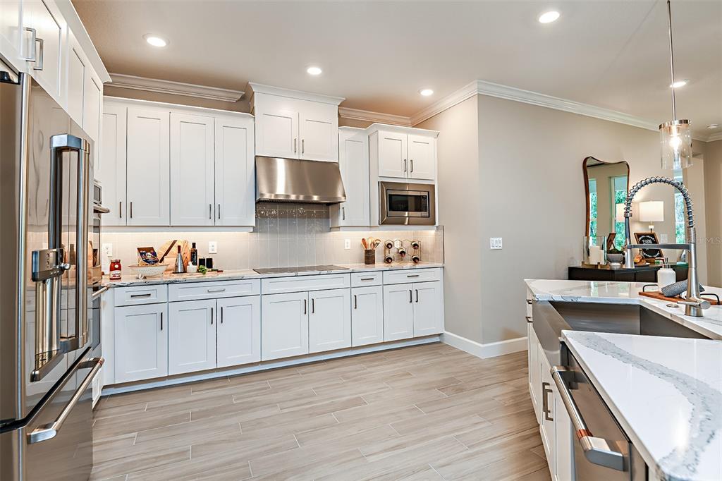 A home office with a desk and shelving sits adjacent to a formal dining room — 19354 LOCHSIDE LANE, MOUNT DORA, FL