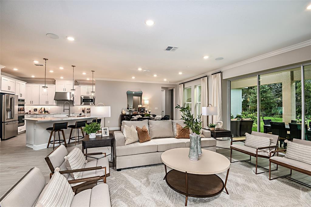 A dining room features a glass table with six chairs, three wall mirrors, and wallpaper — 19354 LOCHSIDE LANE, MOUNT DORA, FL