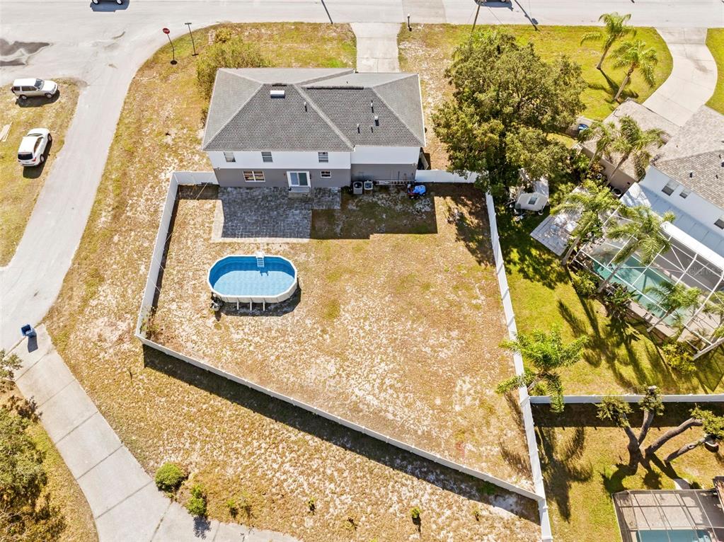 An aerial view shows a house with a fenced backyard containing an above-ground pool — 7319 LAGOON ROAD, SPRING HILL, FL