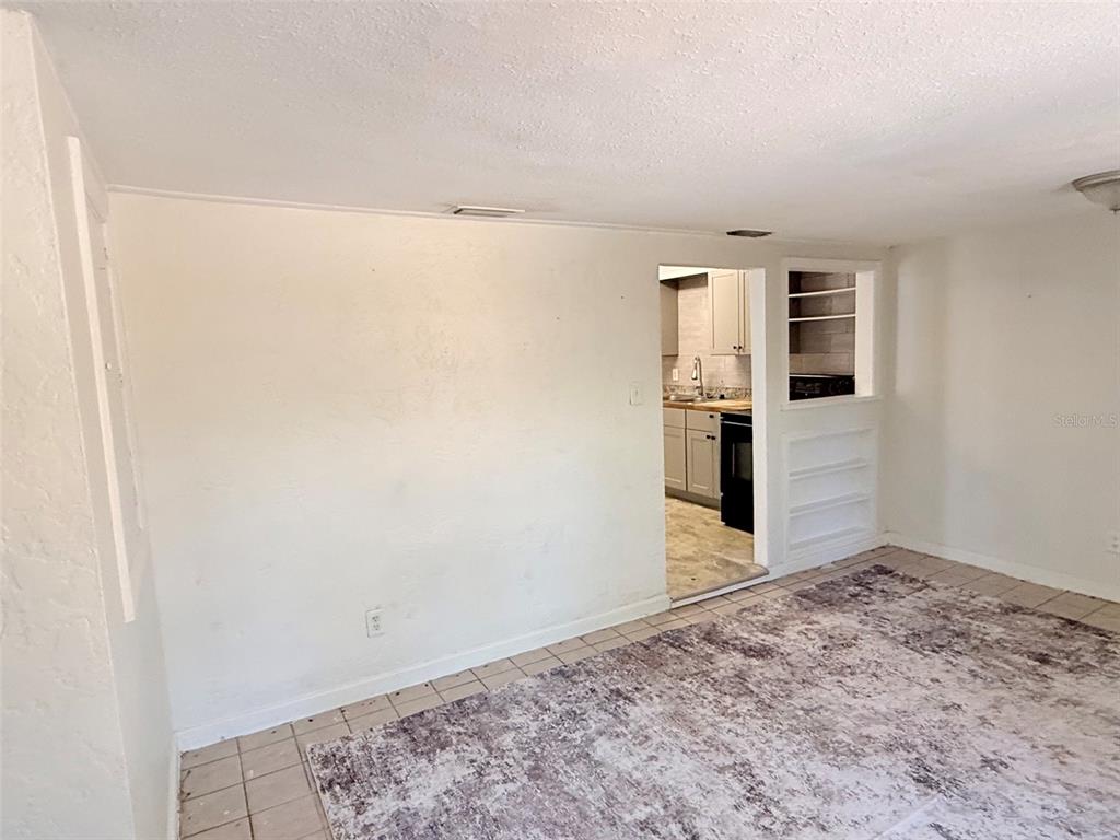 A view from a tiled room looking through a doorway into a kitchen area — 776 27TH AVENUE N UNIT 2, ST PETERSBURG, FL