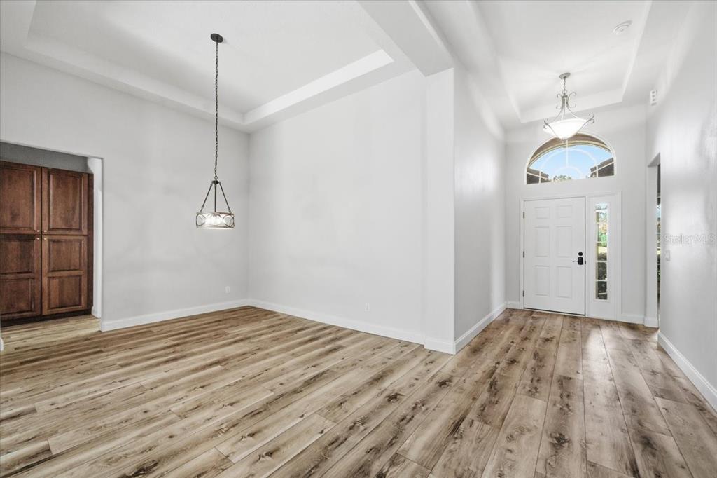 A dining area with wood-look flooring, a tray ceiling, and a pendant light fixture — 1650 W LAUREL GLEN PATH, HERNANDO, FL