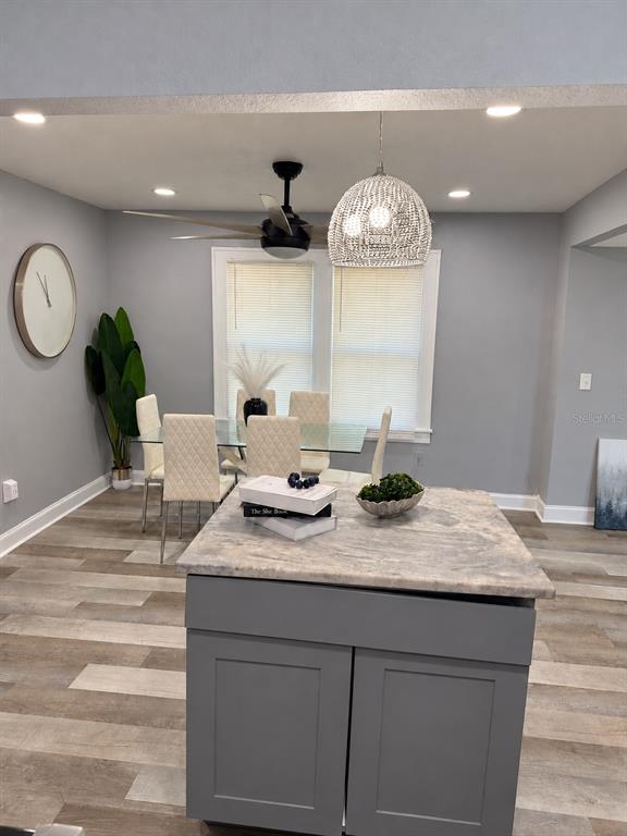 A living room features a black sectional sofa, a ceiling fan, and turquoise curtains — 1340 13TH AVENUE S, ST PETERSBURG, FL