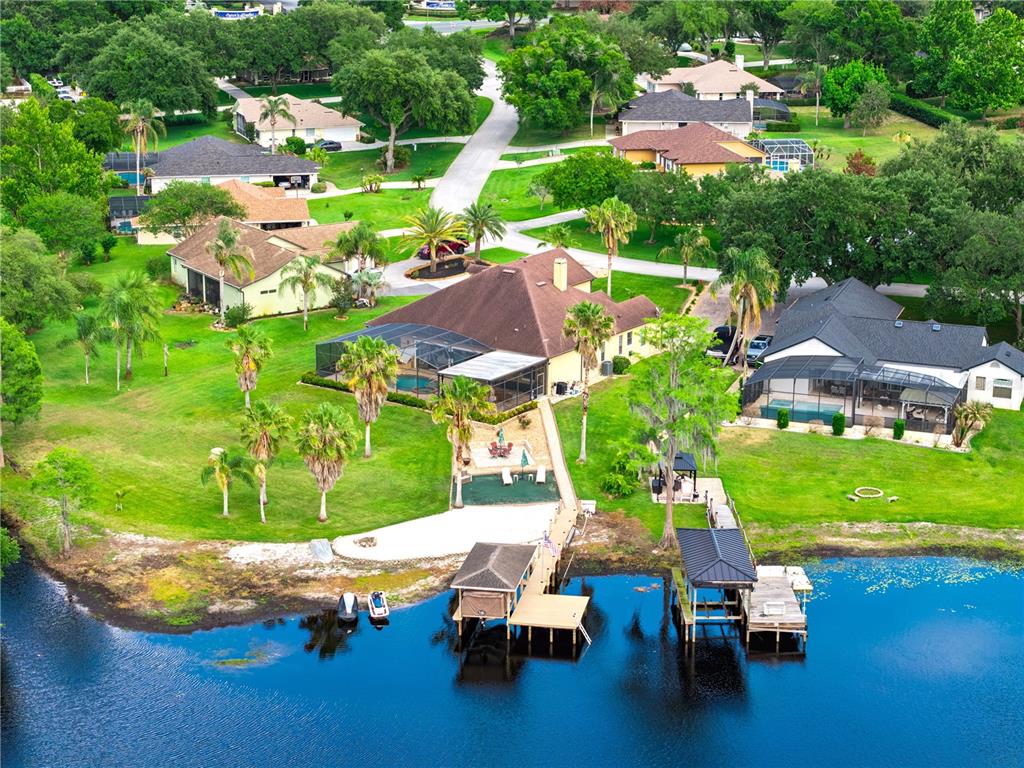 An aerial view of a tan, single-story house with a brown roof and palm trees — 11325 PRESTON COVE ROAD, CLERMONT, FL