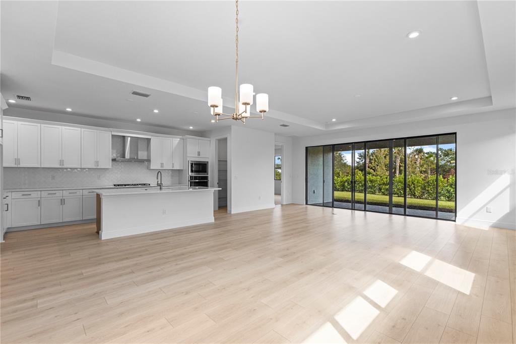 A modern single-story house with a gray stucco exterior and a paved driveway — 5032 LOWLAND TERRACE, PARRISH, FL