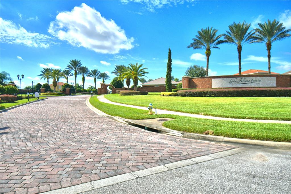 A brick-paved entrance road leads to a landscaped community sign for Lake Juliana Estates — 4383 JULIANA LAKE DRIVE, AUBURNDALE, FL