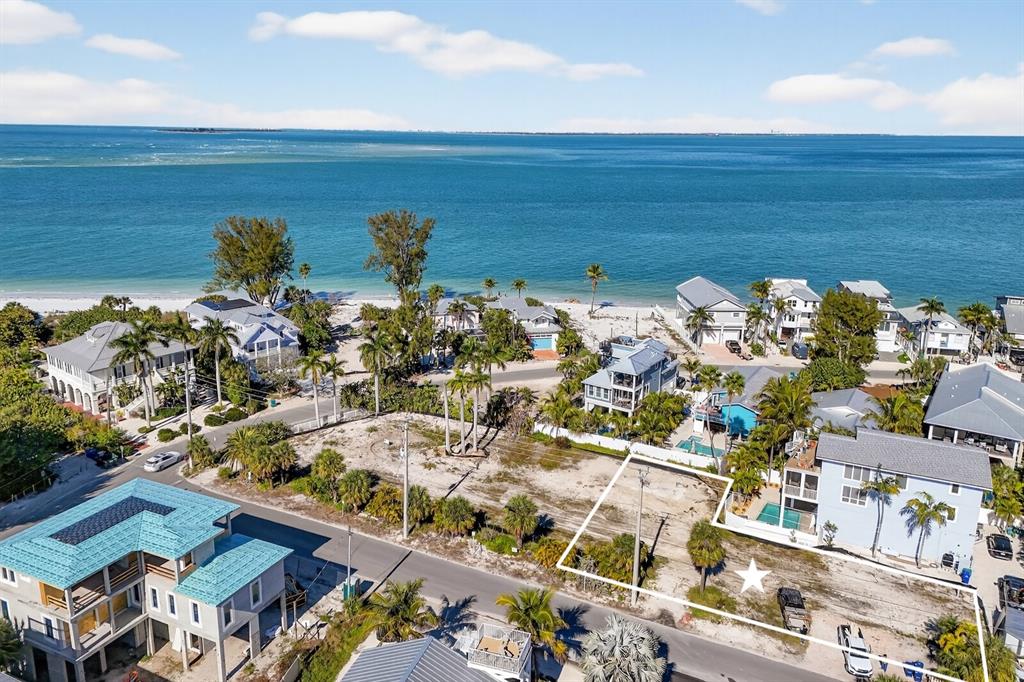 An aerial view shows a vacant coastal lot marked with a star near the ocean — 812 N BAY BOULEVARD, ANNA MARIA, FL