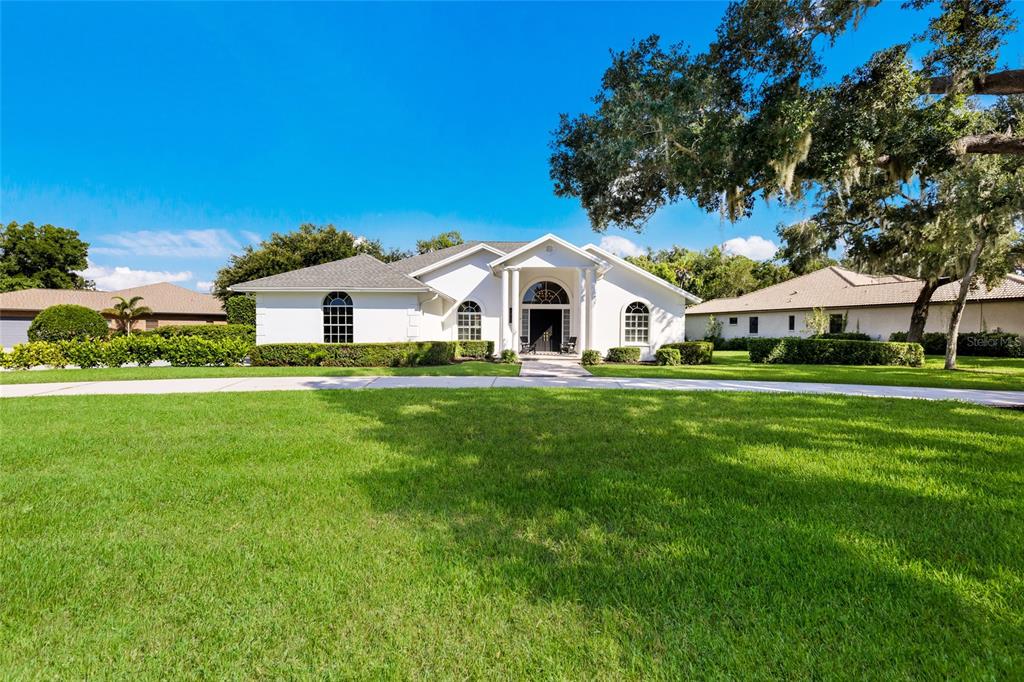 A single-story white house with a columned entryway and a large front lawn — 3649 WILDERNESS BOULEVARD W, PARRISH, FL