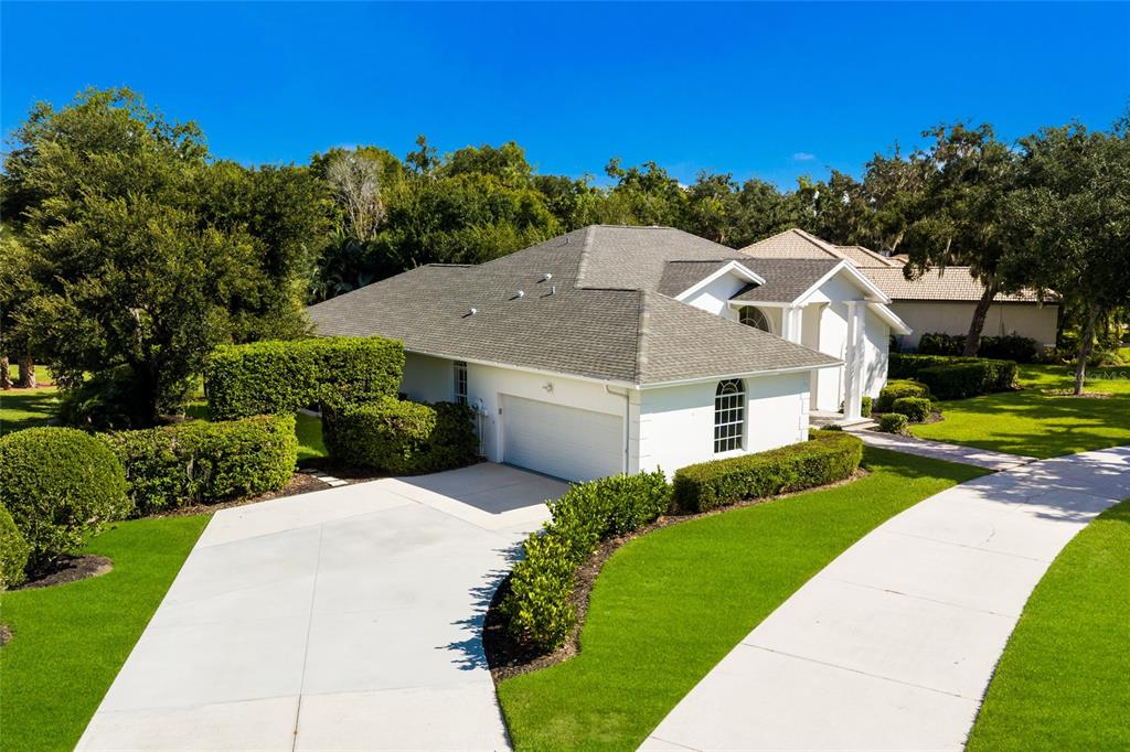 A white single-story house with a gray shingled roof and a paved driveway — 3649 WILDERNESS BOULEVARD W, PARRISH, FL