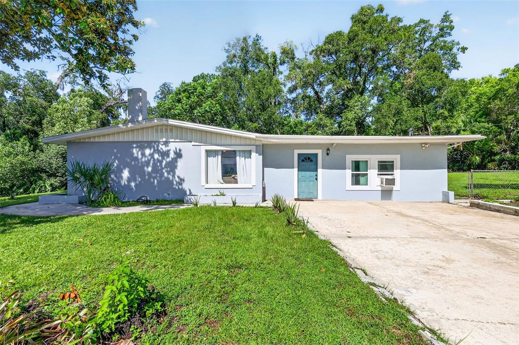 A single-story light blue house with a concrete driveway and a large front lawn — 428 RUTH ST, LONGWOOD, FL