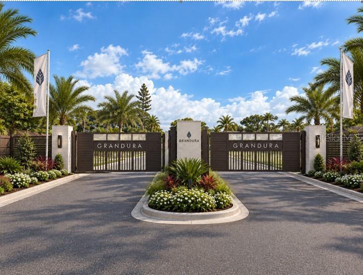 A modern kitchen features white cabinetry, a large island with bar seating, and stainless appliances — 7433 SUMMER COURT, SARASOTA, FL