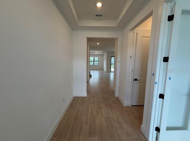 A modern kitchen features white upper cabinets, gray lower cabinets, and a large quartz island — 7433 SUMMER COURT, SARASOTA, FL