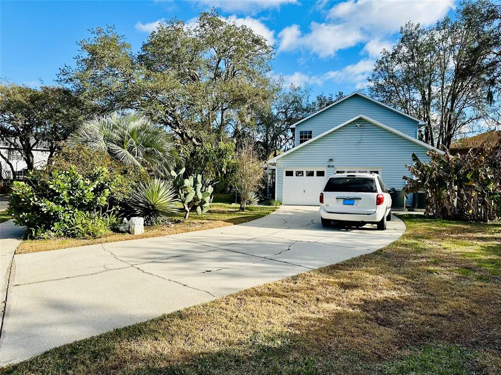 A white SUV is parked in the driveway of a light blue two-story house — 8834 WHISPERING OAKS TRAIL, NEW PORT RICHEY, FL