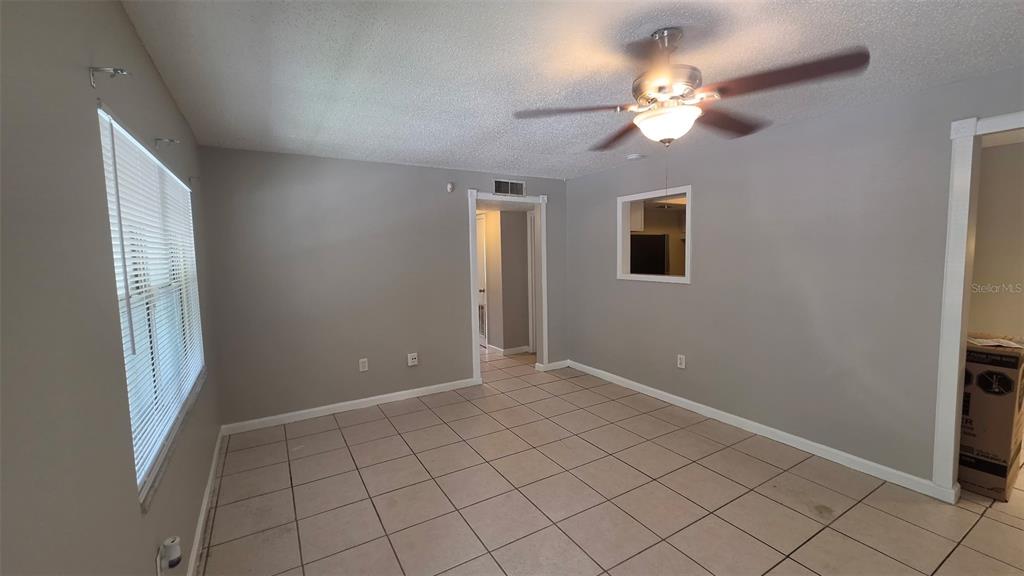 An interior view of a room with beige walls, tiled flooring, and a doorway — 700 E AIRPORT BOULEVARD UNIT B6, SANFORD, FL