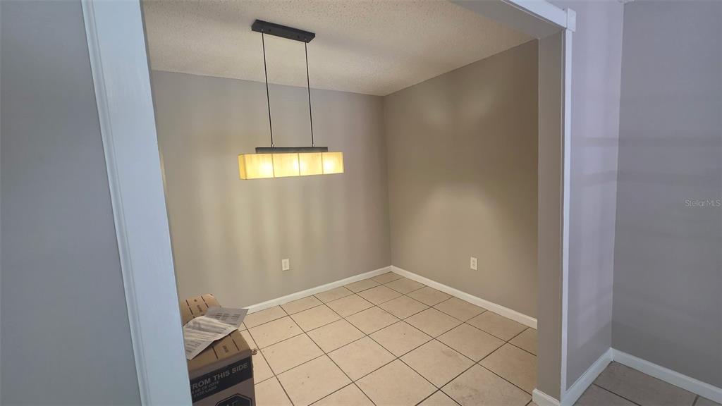 A room with tan walls, a ceiling fan, and light-colored tile flooring — 700 E AIRPORT BOULEVARD UNIT B6, SANFORD, FL
