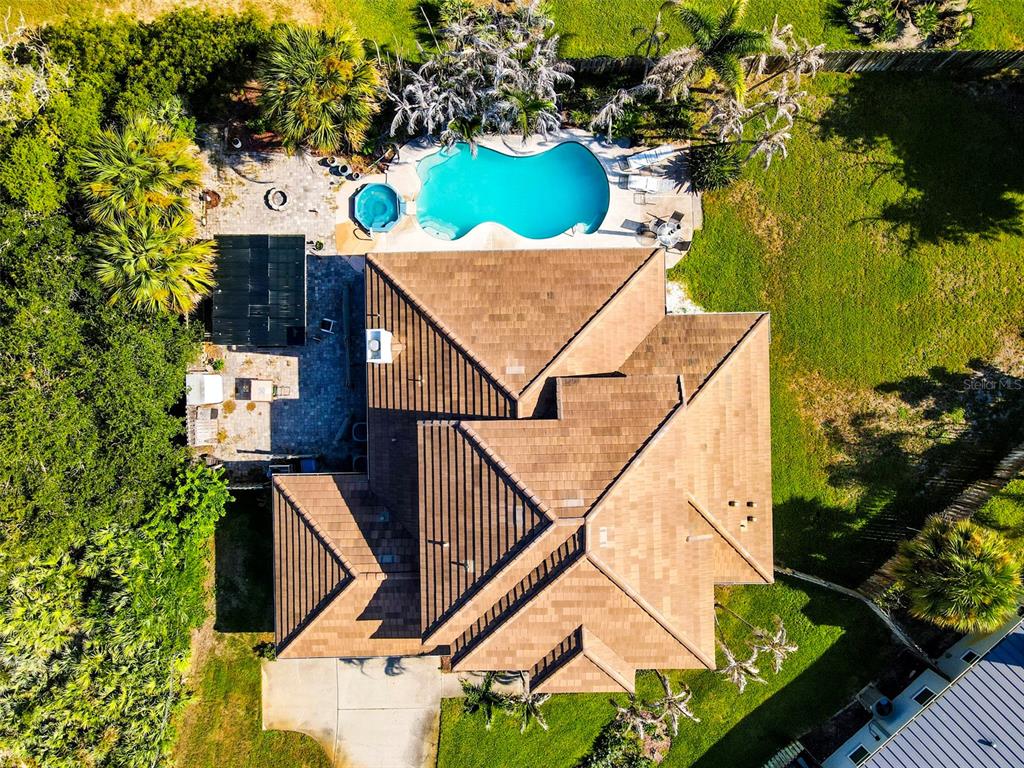 An aerial view of a house with a tiled roof, swimming pool, and backyard landscaping — 3059 N RIO PLUMOSA N, INDIALANTIC, FL