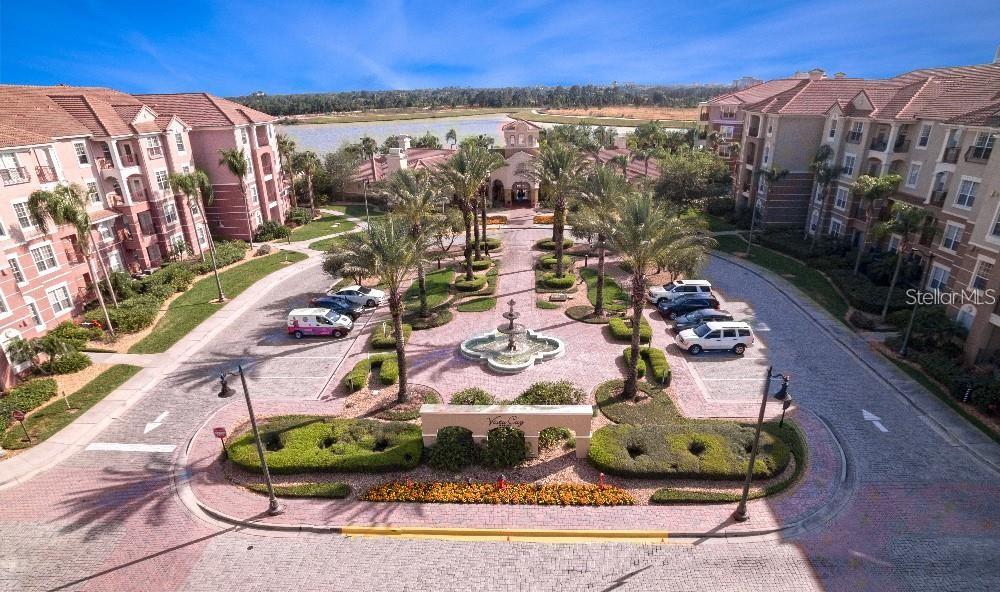 An aerial view shows a paved courtyard with a fountain, palm trees, and surrounding apartment buildings — 5048 SHOREWAY LOOP UNIT 20404, ORLANDO, FL