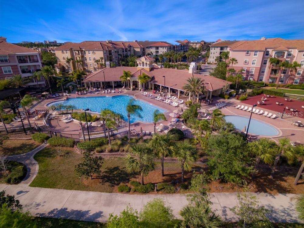 An aerial view of a resort-style swimming pool complex surrounded by multi-story apartment buildings — 5048 SHOREWAY LOOP UNIT 20404, ORLANDO, FL