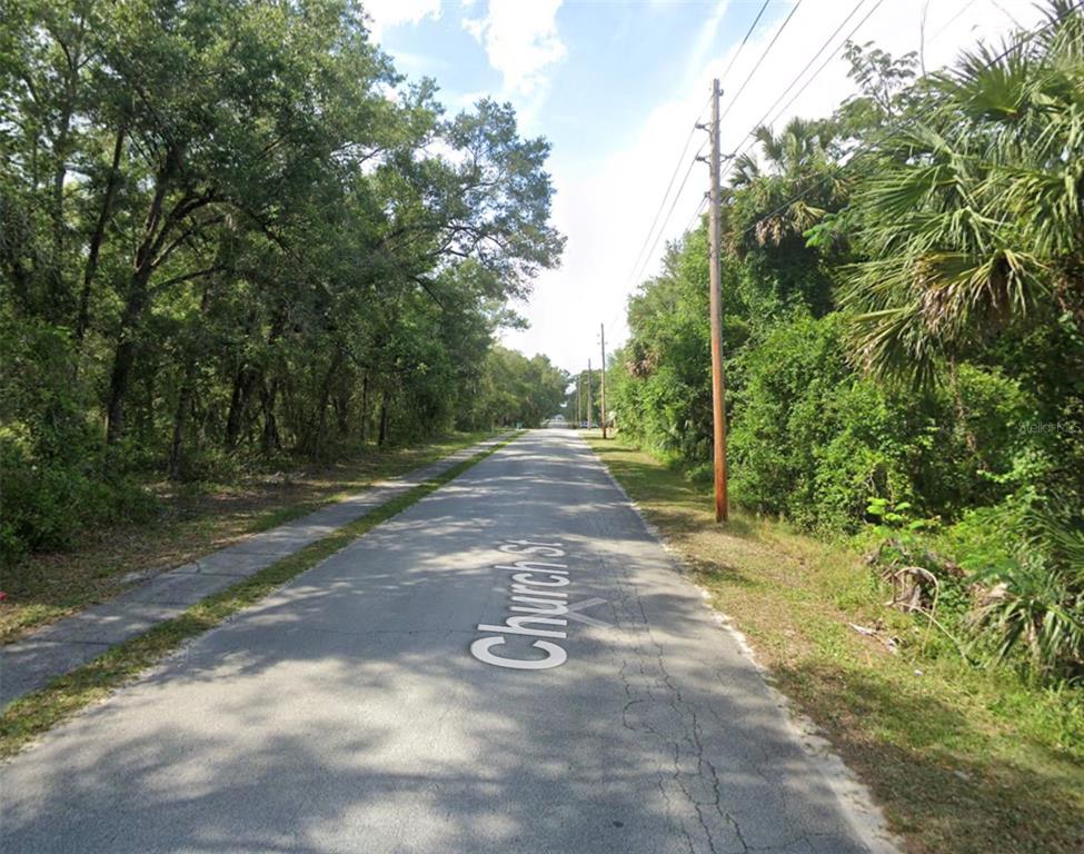 A paved road named Church St runs through a wooded area with utility poles — 426 CHURCH, LAKE HELEN, FL