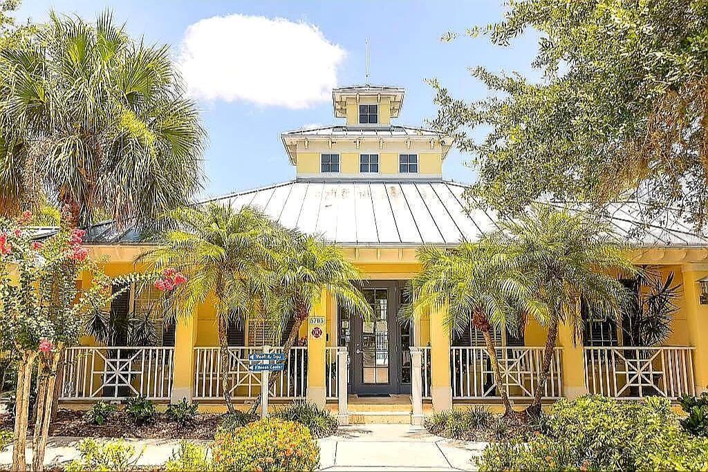 A yellow building with a metal roof, a cupola, and a front porch with railings — 5662 WHITEHEAD STREET, BRADENTON, FL