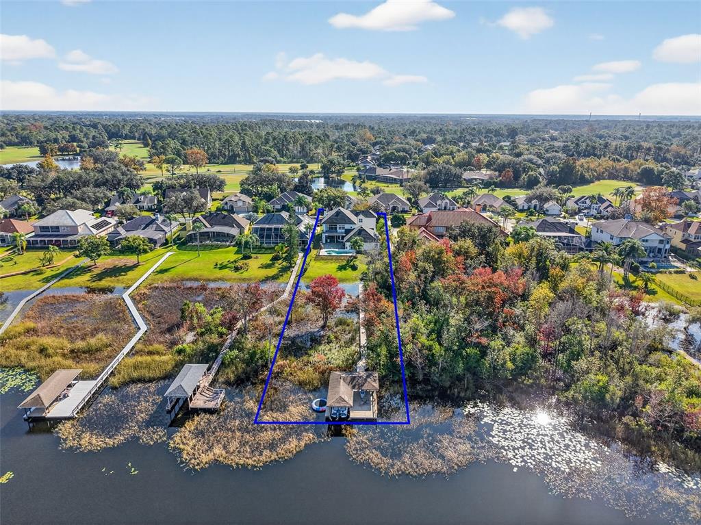 An aerial view shows a house with a private dock extending into a lake — 1741 EDGEWATER DRIVE, MOUNT DORA, FL