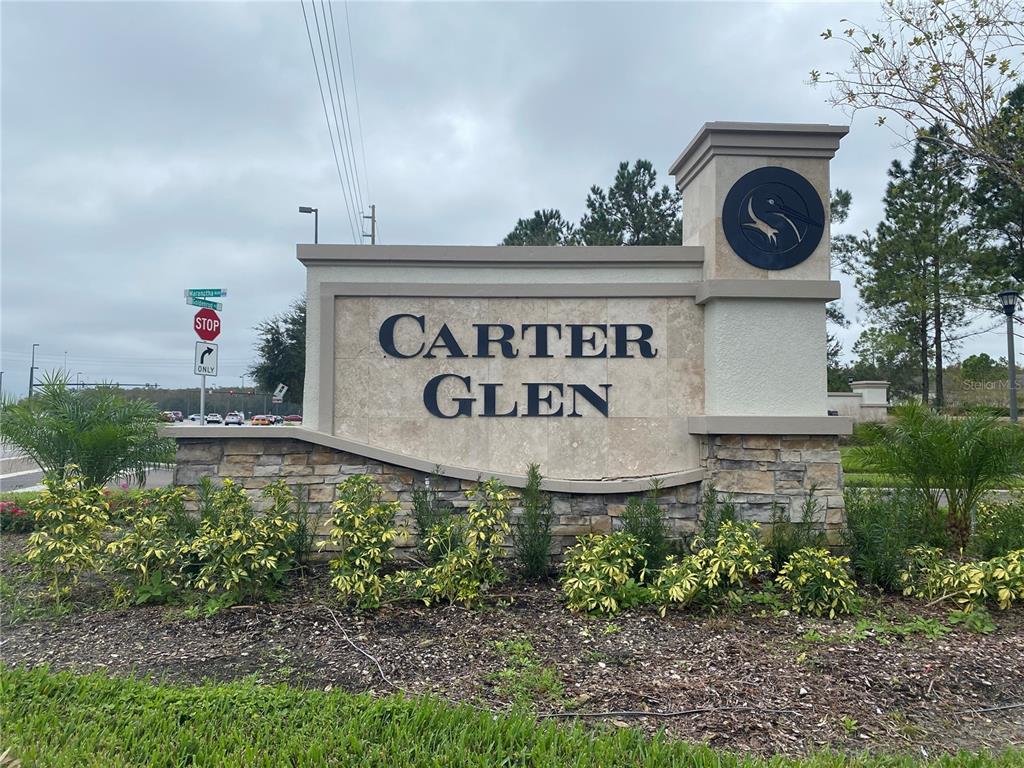 A stone monument sign for the Carter Glen community stands in a landscaped garden area — 6660 S GOLDENROD ROAD UNIT 126B, ORLANDO, FL