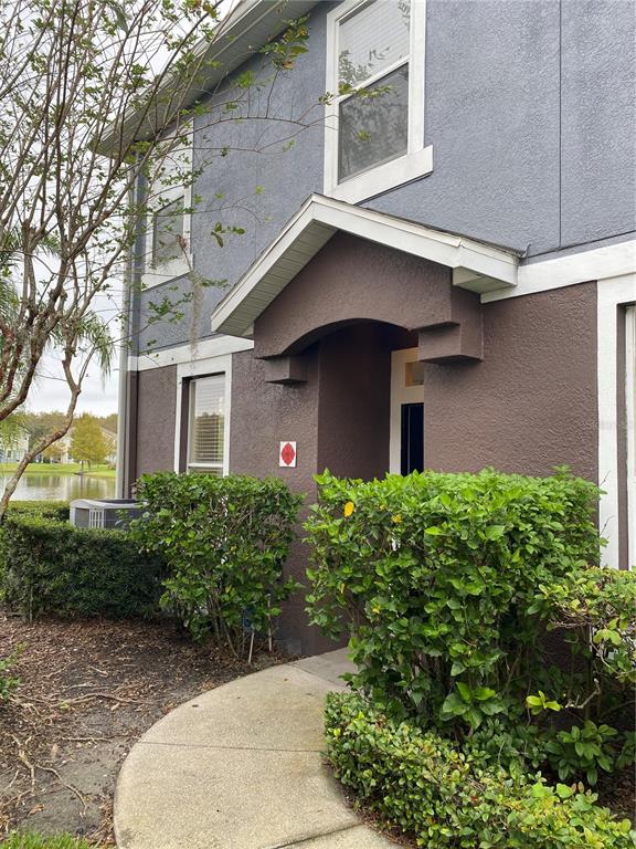 A two-story building exterior features a covered entryway, stucco walls, and surrounding landscaping — 6660 S GOLDENROD ROAD UNIT 126B, ORLANDO, FL