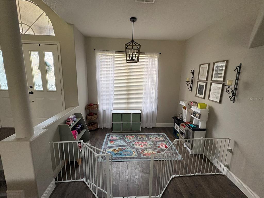 A beige house exterior features a covered entryway with white columns and a curved arch — 8706 LINEBROOK DRIVE, TRINITY, FL